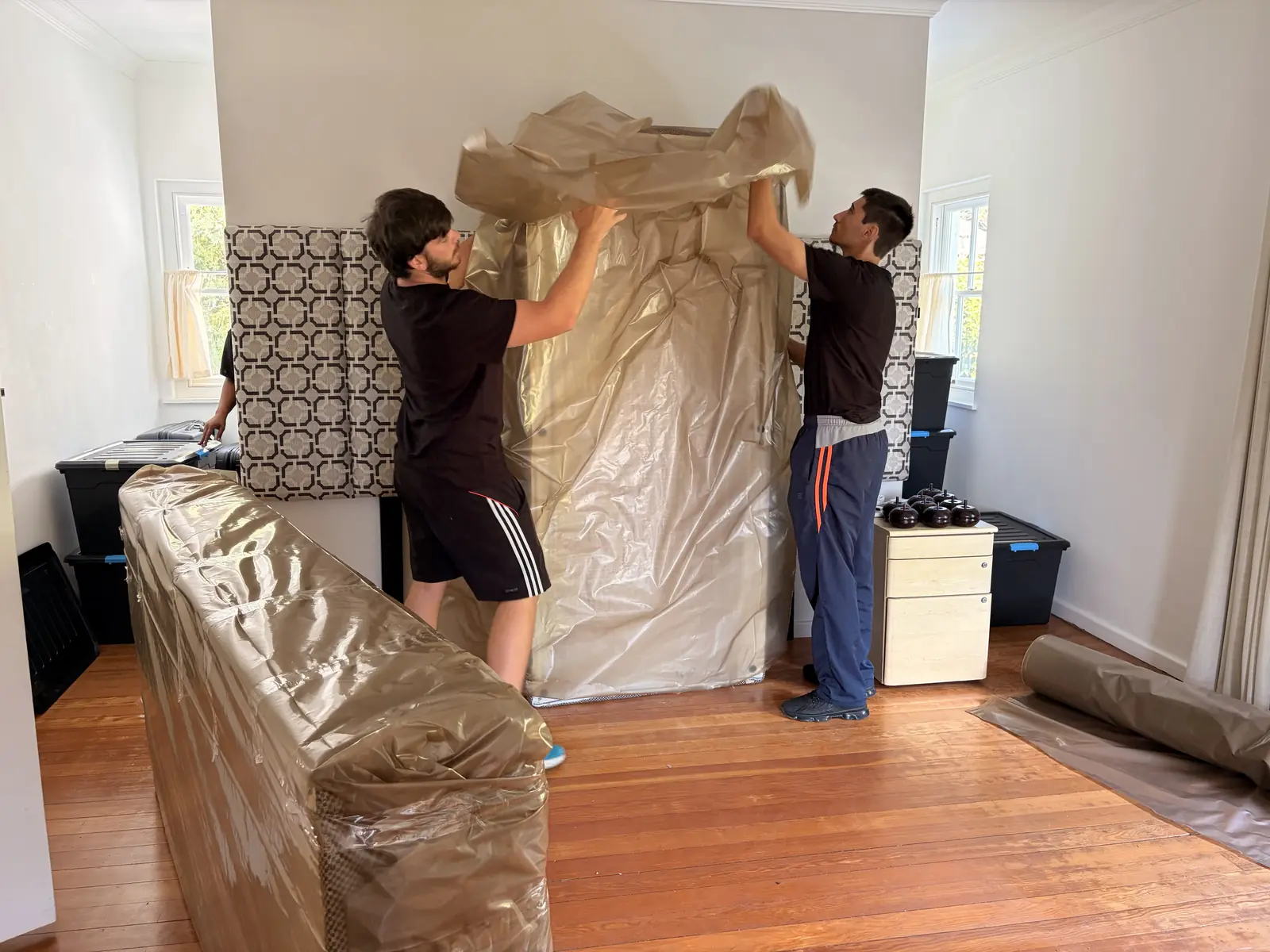 Team members working together to wrap a large bed base
